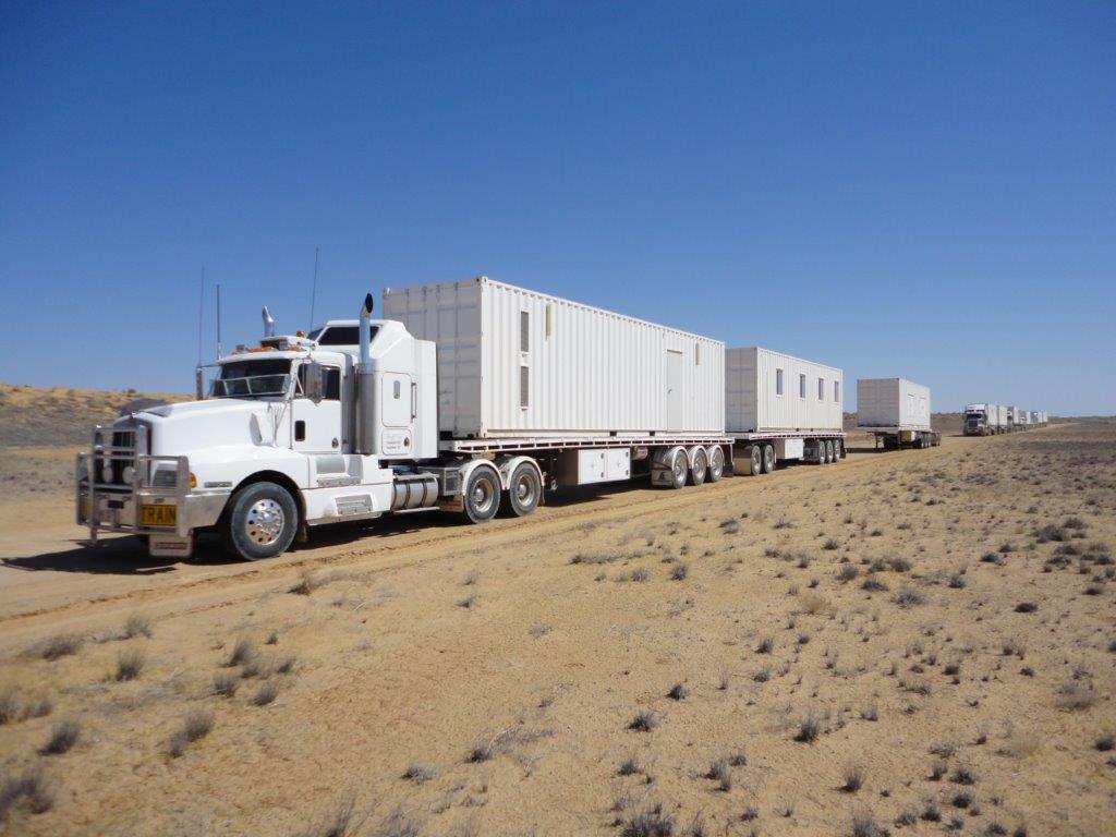 White haulage truck transporting trailers across a desert road White haulage truck transporting trailers across a desert road