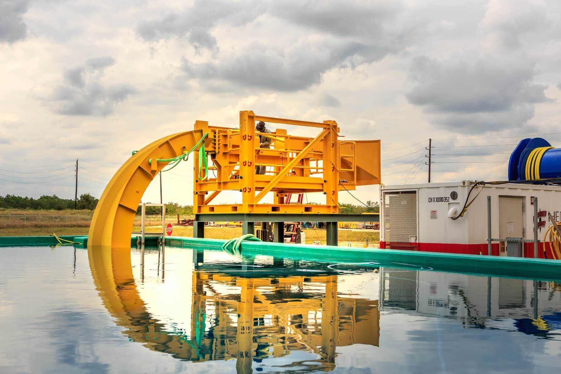 Image of yellow piece of equipment with part submerged in tank of water