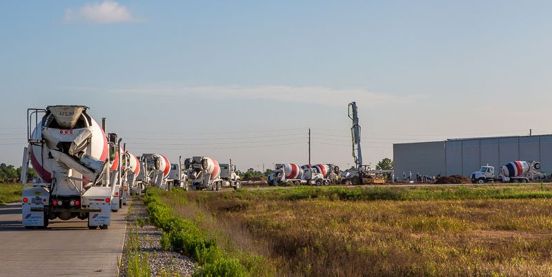 Image of several cement trucks driving along a road